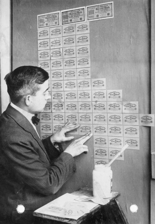 1923年ドイツのハイパーインフレ 価値を失った紙幣で壁を貼る様子