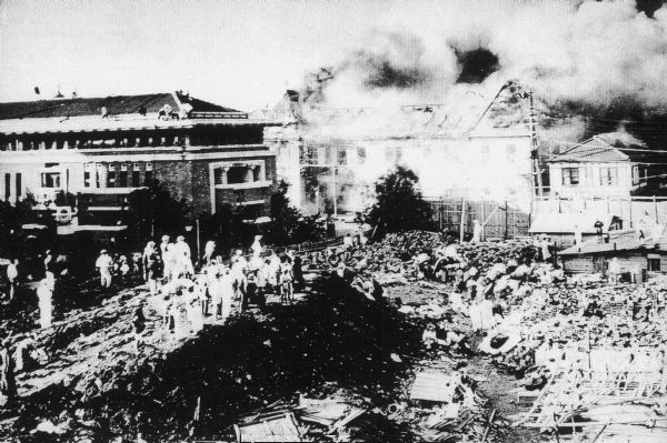 関東大震災で無傷だった帝国ホテル（右）と燃え上がる周辺建物（1923年）